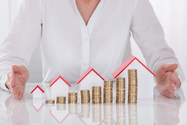 Businesswoman Hands Protecting Coins And House Models