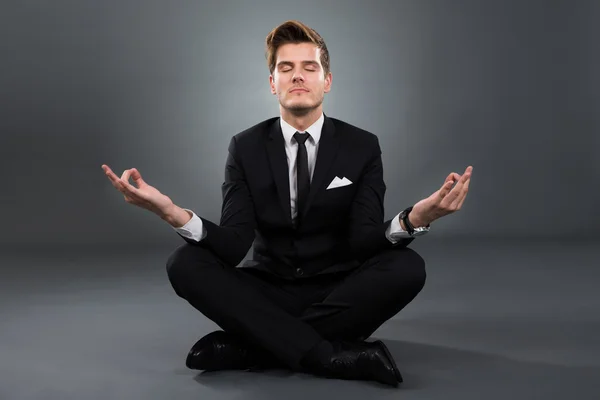 Businessman Practicing Yoga In Lotus Position