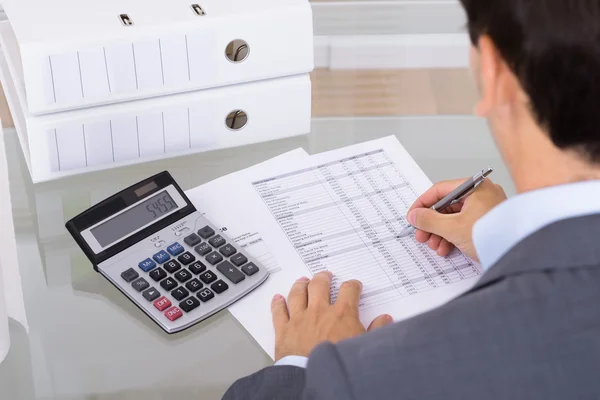 Male accountant calculating invoices