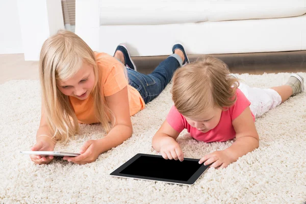Kids Using Tablet Lying On Carpet