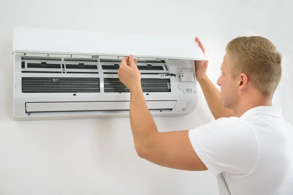 Man Adjusting Air Conditioning System