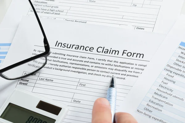 Hand With Insurance Claim Form