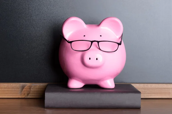 Piggy Bank With Glasses On Book