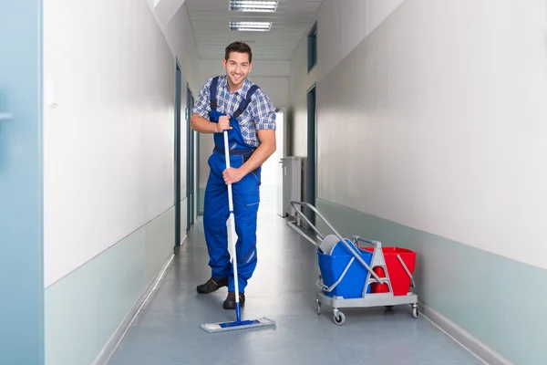 Male Worker Cleaning Office Corridor