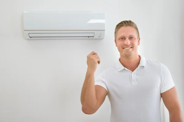 Man With Air Conditioner Remote Controller