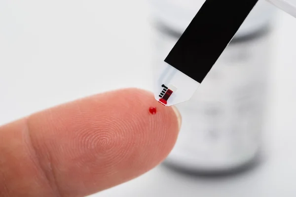 Person's Finger With A Glucometer