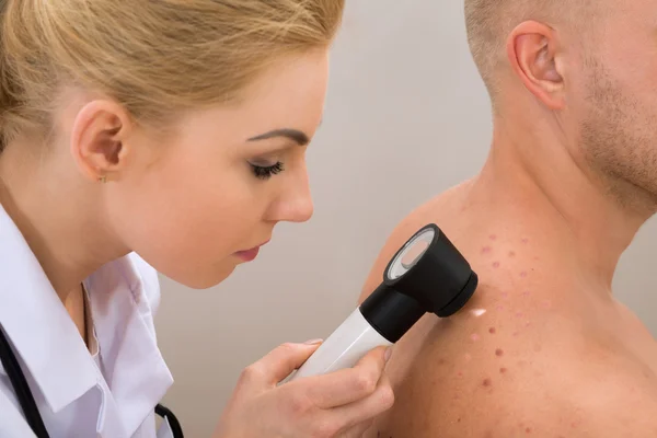 Doctor Examining Pigmented Skin