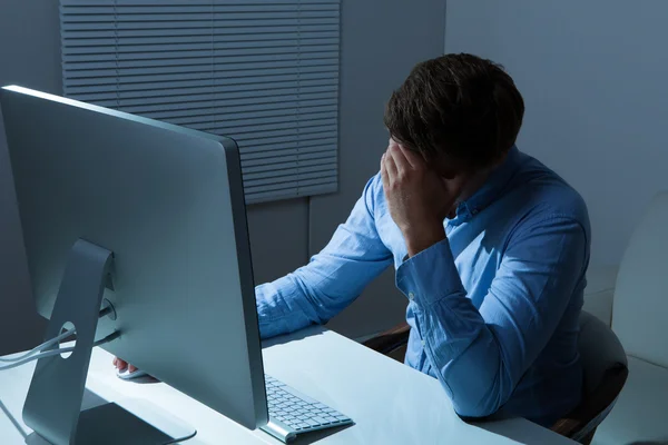 Over stressed Businessman Leaning At Computer