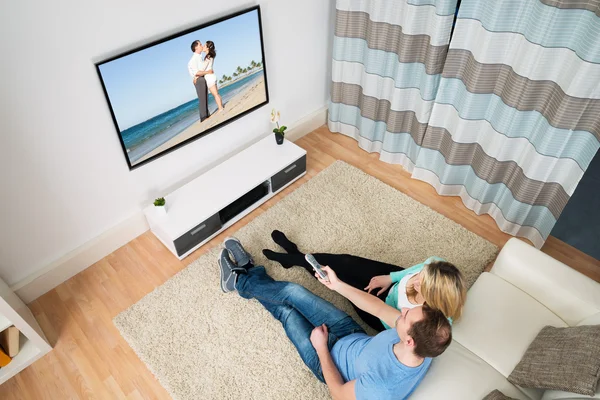 Couple Sitting In Front Television