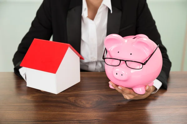 Businesswoman With House And Piggybank