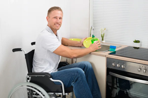 Man On Wheelchair Washing Dishes
