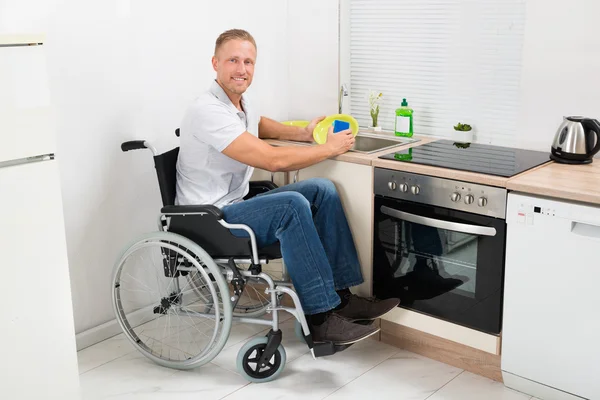 Disabled Man On Wheelchair Washing Dishes