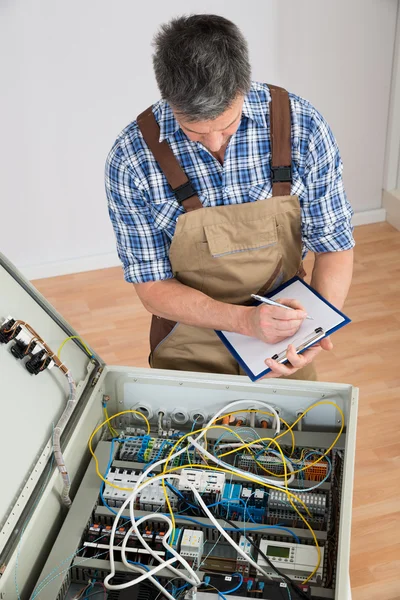 Electrician Looking At Fuse Box