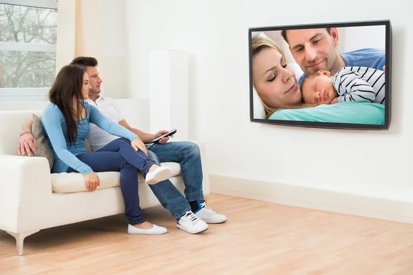 Couple In Living room Watching Television