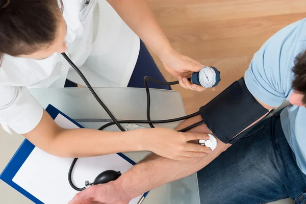 Female Doctor Checking Blood Pressure