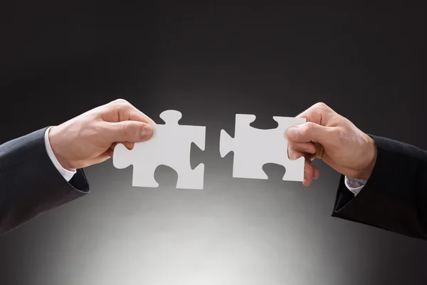 Businesspeople Connecting Jigsaw Puzzle