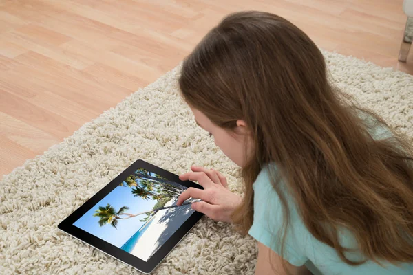Girl On Carpet Looking At Digital Tablet