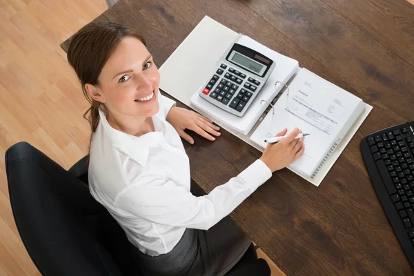 Businesswoman With Invoice And Calculator