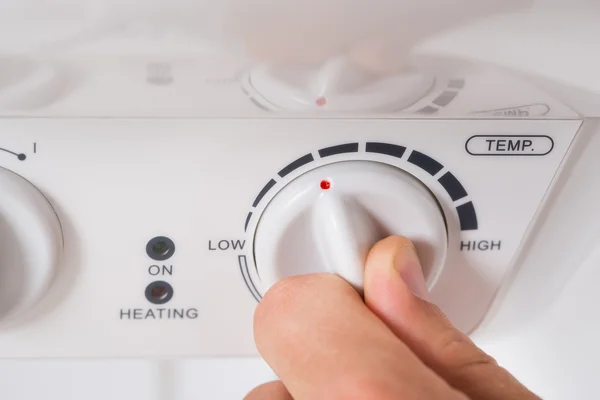 Person Turning The Knob Of Electric Boiler