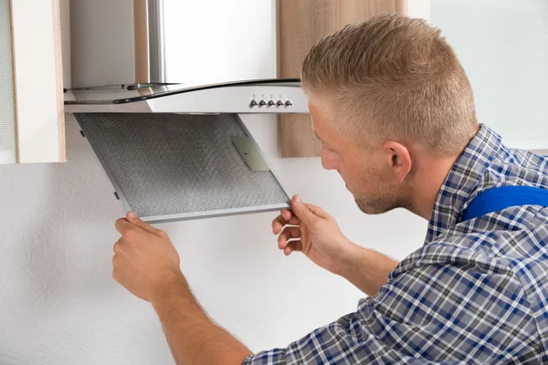 Repairman Repairing Kitchen Extractor Filter