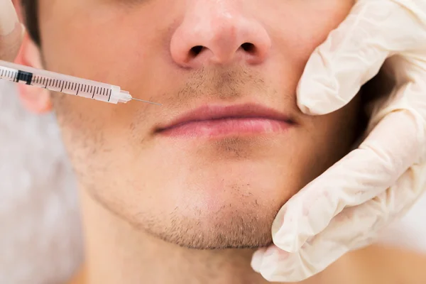 Doctor Giving Injection On Face Of Man