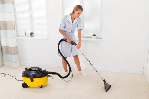 Female Maid Vacuuming Floor