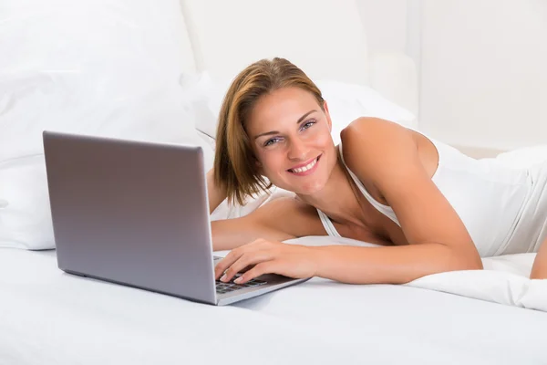 Woman With Laptop On Bed
