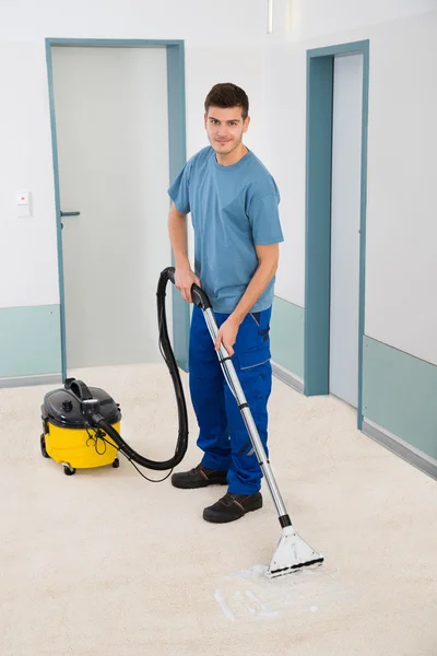 Male Cleaner Vacuuming Floor