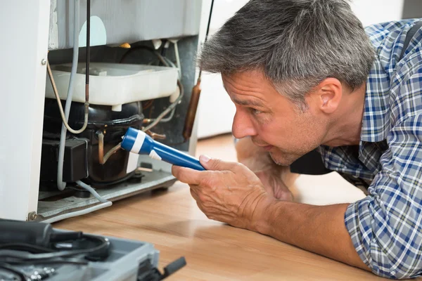 Handyman Checking Refrigerator