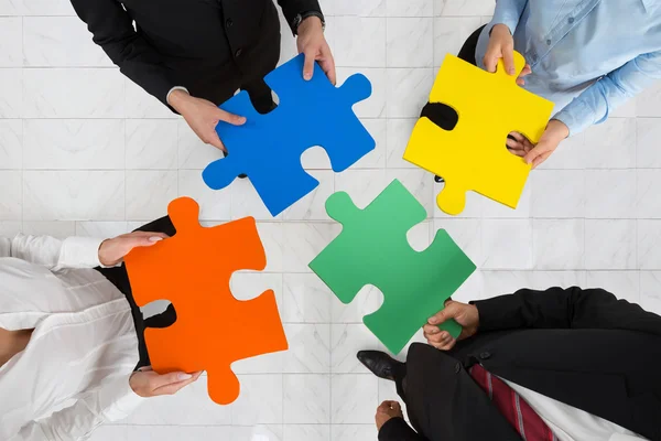 Businesspeople Holding Puzzle Pieces