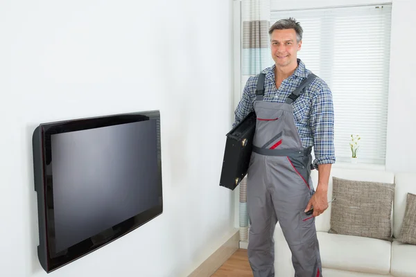 Technician With TV Set Top Box At Home