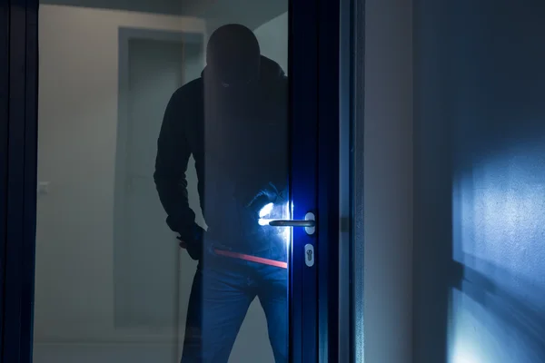 Burglar Using Crowbar To Open Door