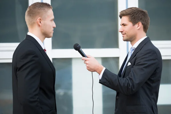 Journalist Interviewing Businessman Outdoors