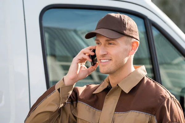 Smiling Delivery Man Using Mobile Phone