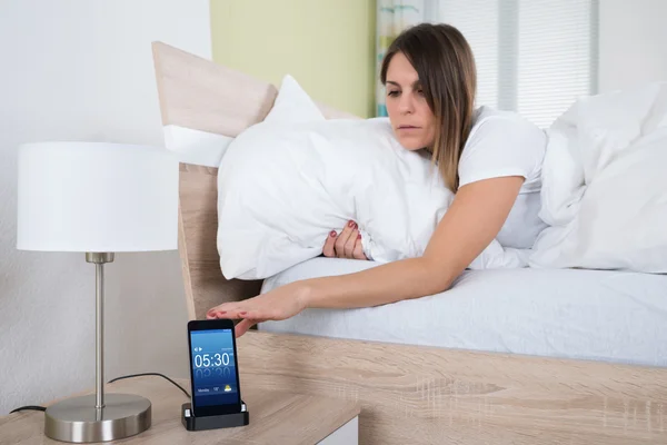 Woman On Bed Snoozing Alarm