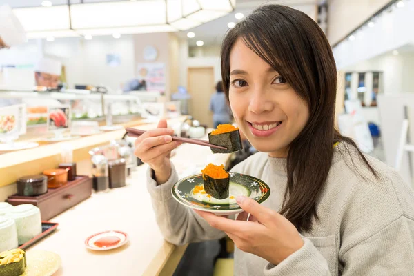 Woman enjoying sushi at japanese restaurant