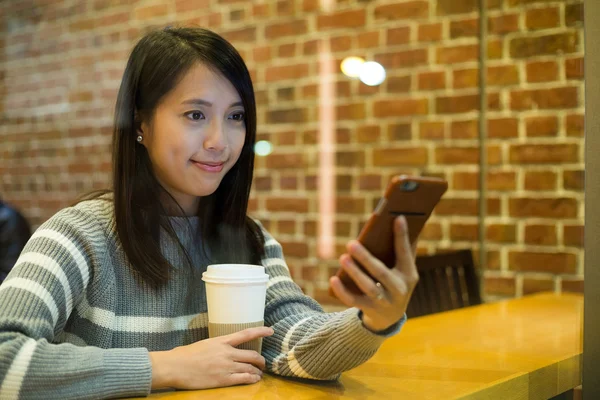Woman using smart phone in cafe