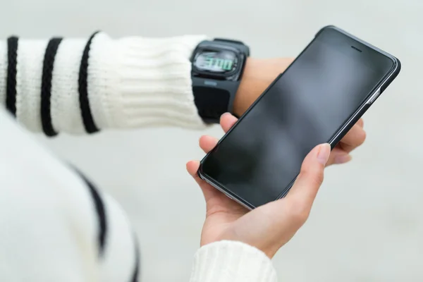 Woman connecting mobile phone with smart watch