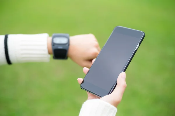 Woman connecting mobile phone with smart watch