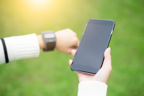 Woman connecting mobile phone with smart watch