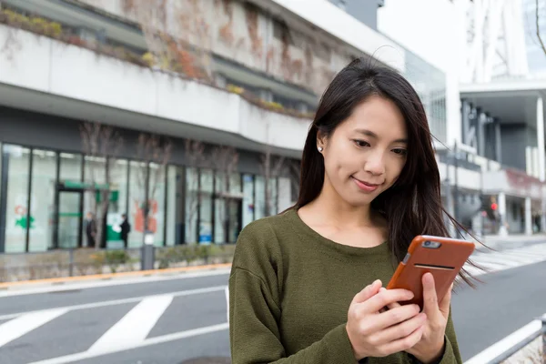 Woman using mobile phone on the street