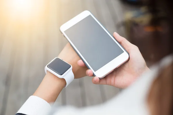 Woman connecting smart watch and cellphone