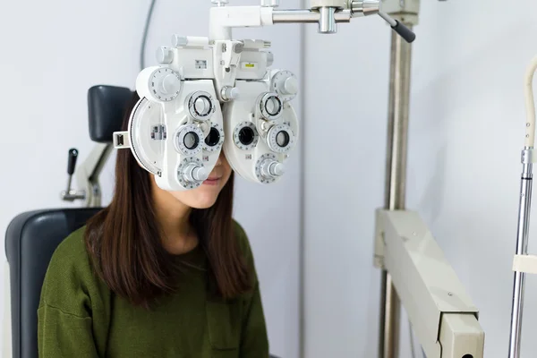 Woman doing eye test in optical clinic