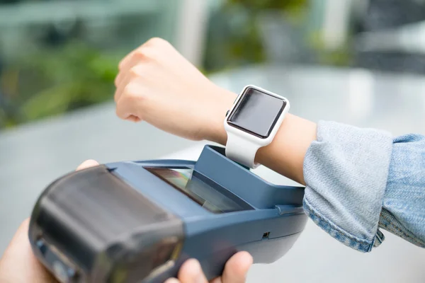 Woman paying the bill by smart watch