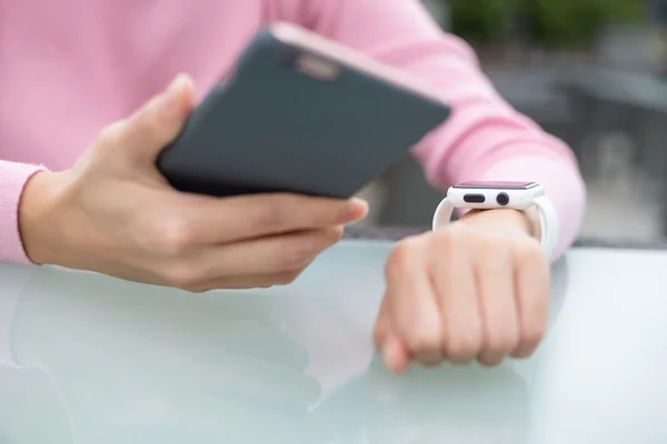 Woman connecting smart watch and cellphone