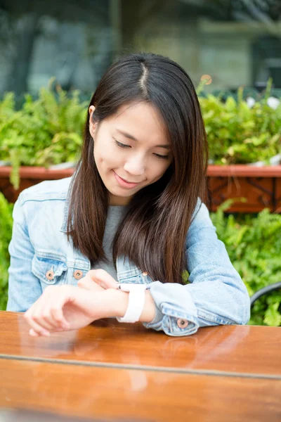 Woman using smart watch at outdoor cafe