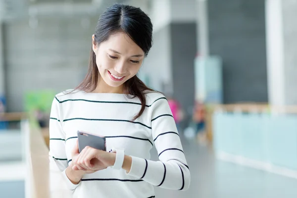 Woman connecting cellphone and smart watch