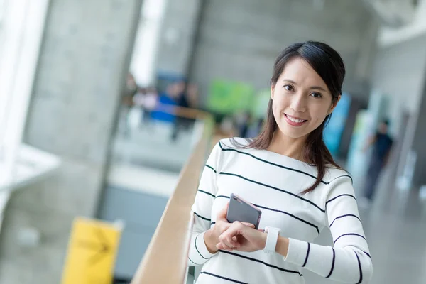 Woman using mobile phone and smart watch