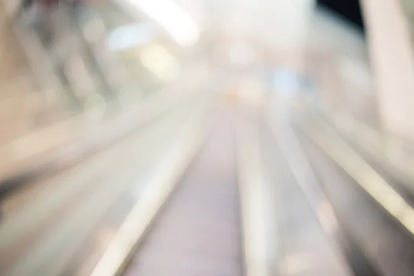 Blur escalator in shopping mall with bokeh for background