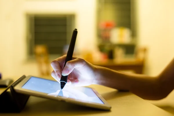 Woman drawing on tablet with pen